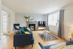 a living room with a blue couch and a fireplace at Listers Nest in Exley