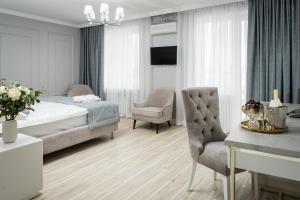 1 dormitorio con 1 cama, 1 silla y 1 mesa en Rakhat Hotel, en Uralsk