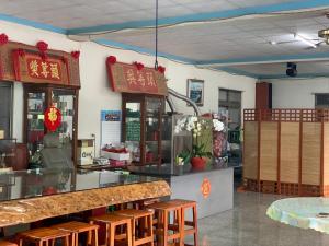 a restaurant with a counter and some stools at Youlin Homestay in Meishan