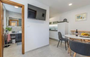 a kitchen and dining room with a table and a television at Guesthouse Casa Nova in Poreč