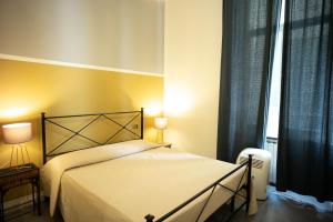 Un dormitorio con una cama y dos lámparas y una ventana. en La Casa di Napoleone, en La Spezia