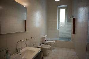 Un baño con lavabo, inodoro y ventana. en La Casa di Napoleone, en La Spezia 15 fotos más