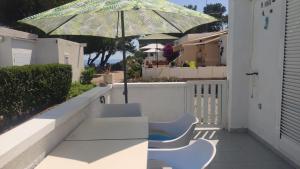 eine Terrasse mit einem Tisch, Stühlen und einem Sonnenschirm in der Unterkunft Mi morena cala llobeta 35 in L'Ametlla de Mar