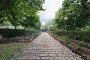 a stone path in a park with trees and lights at Villa Il Castagno dell'Etna in Maletto