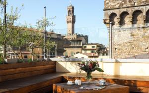 una mesa con un jarrón de flores en el balcón en AQA Palace, en Florencia