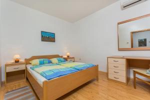 a bedroom with a bed and a dresser and a mirror at Guesthouse Casa Nova in Poreč