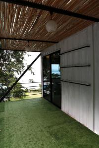 a building with a door and a grass yard at Bamboo Garden House in Laem Sing