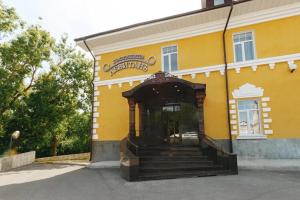 un edificio amarillo con escaleras delante en Hotel Levitan en Vladimir