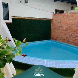 a swimming pool in a backyard with a brick wall at CrisAl Suite Posada in J. Saldivar