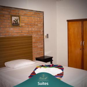 a bed in a room with a brick wall at CrisAl Suite Posada in J. Saldivar