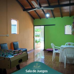 a living room with a ping pong table and chairs at CrisAl Suite Posada in J. Saldivar