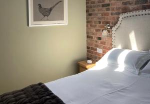 a bedroom with a bed and a picture of a chicken on the wall at Rowley Farm Holidays in Worcester