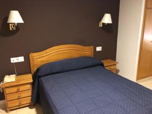 a bedroom with a blue bed and two night stands at Hotel Gil in Montanejos