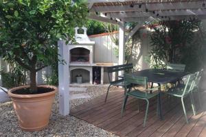 d'une terrasse avec une table, des chaises et une cheminée. dans l'établissement Villa bord de mer, à Torreilles