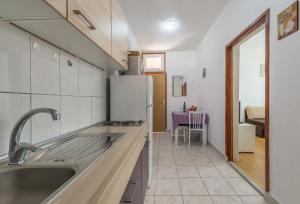 eine Küche mit einer Spüle und einem Kühlschrank in der Unterkunft Apartmani Mlinar9 #1 in Gornji Karin