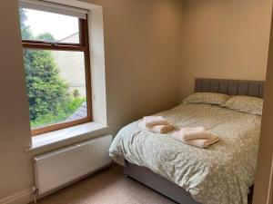 a bedroom with a bed with two towels on it at Nab View Cottage in Whalley