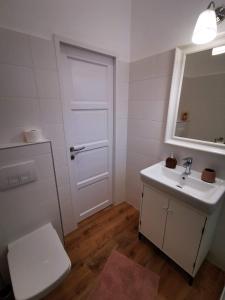 a bathroom with a toilet and a sink and a mirror at GOLD 2 Apartman in Sopron