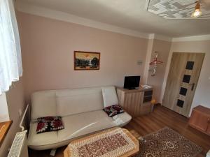 a living room with a white couch and a television at Privát u Bartolomeja in Štrba