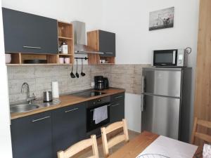 a kitchen with a sink and a refrigerator at GOLD 2 Apartman in Sopron
