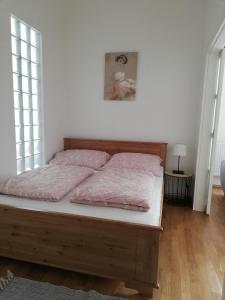 Un dormitorio con una cama con sábanas rosas. en GOLD 2 Apartman en Sopron