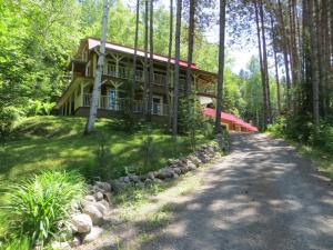 una casa en el bosque con una carretera delante de ella en La Maison sous les arbres, en Saint Roch de Mekinac