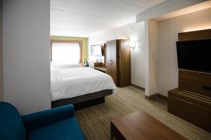 a hotel room with a bed and a flat screen tv at Holiday Inn Express & Suites Knoxville-Farragut by IHG in Knoxville