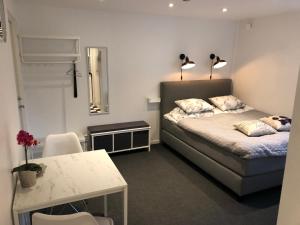 a bedroom with a bed and a table and two lamps at Smultronstallet Gårdshotell in Valleberga