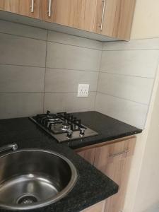 a kitchen with a sink and a stove at Salas Stay, Midrand in Midrand