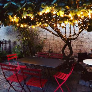 uma mesa e cadeiras debaixo de uma árvore com luzes em Gîte de la moinette em Azé