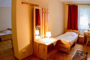a small bedroom with a bed and a mirror at Hostel Rest in Kraków