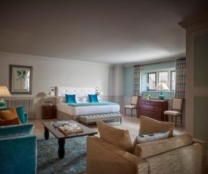 a bedroom with a bed and a living room at Whatley Manor in Malmesbury