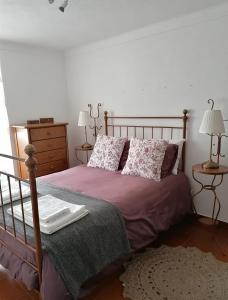 カステロ・デ・ヴィデにあるcasa28のベッドルーム1室(紫のシーツと枕が備わるベッド1台付)