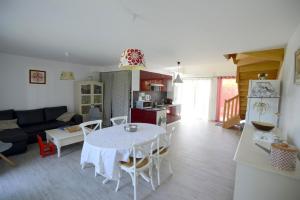 una cucina e un soggiorno con tavolo e sedie di Fleur de Lys a Mer
