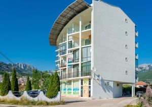 a tall white building with an archway at Apartment Hanja in Bar