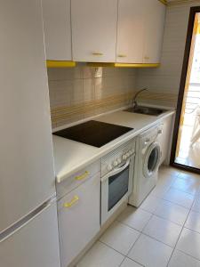 a kitchen with a stove and a washing machine at Miraplaya in Benicàssim