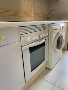 a kitchen with a white oven and a washing machine at Miraplaya in Benicàssim