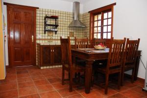 Casa Rural La Casa de La Lima في Las Rosas: مطبخ مع طاولة وكراسي خشبية في الغرفة