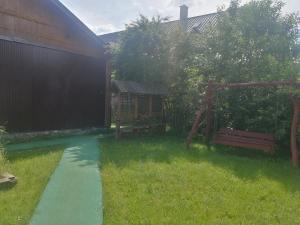un jardín con un sendero y un banco en el césped en Ostoja, en Białowieża