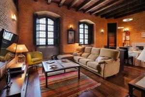 uma sala de estar com um sofá e uma mesa em Castillo de Monte la Reina Posada Real & Bodega em Toro