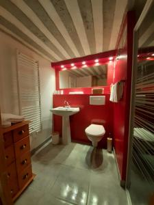 a red bathroom with a toilet and a sink at Le Manaïrou in Valdeblore