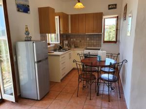 a kitchen with a table and chairs and a refrigerator at Stoupa Mani Tower in Stoupa