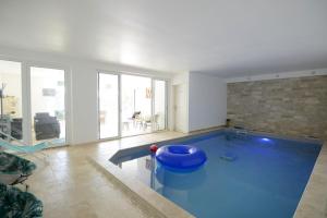 uma sala de estar com uma grande piscina azul em Fleur de Lys em Mer