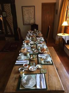 una larga mesa de madera con platos y platos. en La rabouillere, en Contres