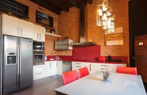 uma cozinha com cadeiras vermelhas e um frigorífico de aço inoxidável em Castillo de Monte la Reina Posada Real & Bodega em Toro