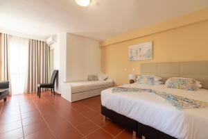 a hotel room with two beds and a chair at Manta Guest - Manta Rota Beach in Manta Rota +33 photos