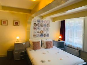 a bedroom with a bed with two tables and two lamps at Amsterdam Central Guest House in Amsterdam