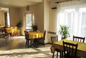 a dining room with tables and chairs and windows at Hostel Rest in Krakow