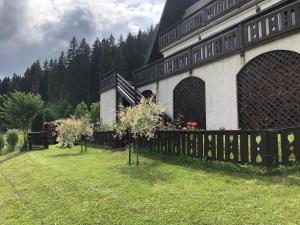 un bâtiment avec une clôture devant une cour dans l'établissement Bucovina Lodge Pension, à Vama