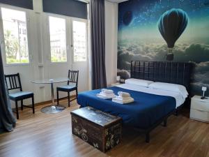 - une chambre avec un lit orné d'une peinture représentant une montgolfière dans l'établissement Flats Friends Plaza de la Reina, à Valence
