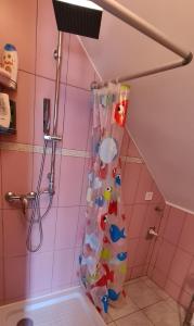 y baño rosa con ducha y cortina de ducha. en Lóczy-Lak, en Siófok